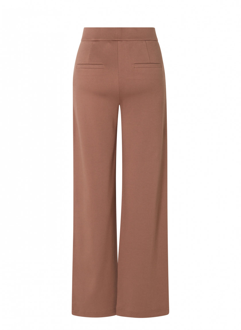 De Paloma Essential, een zachte pantalon met hoge taille, wijde pijpen van bruine jersey met een elastische tailleband en twee paspelzakken achter, is van achteren afgebeeld op een effen witte achtergrond. Verkrijgbaar in 4 kleuren.
